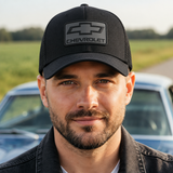 Close-up of a male model wearing the black Chevrolet 3D Badge Trucker Cap, showing the raised Chevrolet badge.