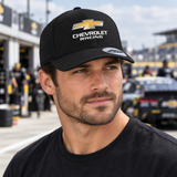 Male model wearing the black Chevrolet Racing Breathable Cap in a motorsport paddock.